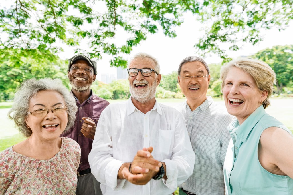 A small group of older adults participate in an older adult learning program at a park outside.