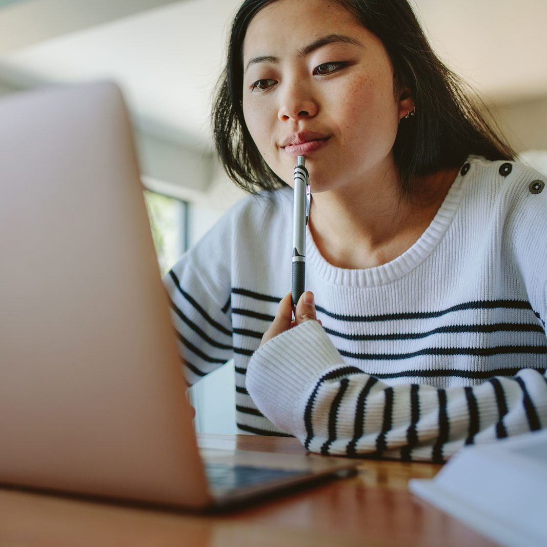 A young student works on her laptop.