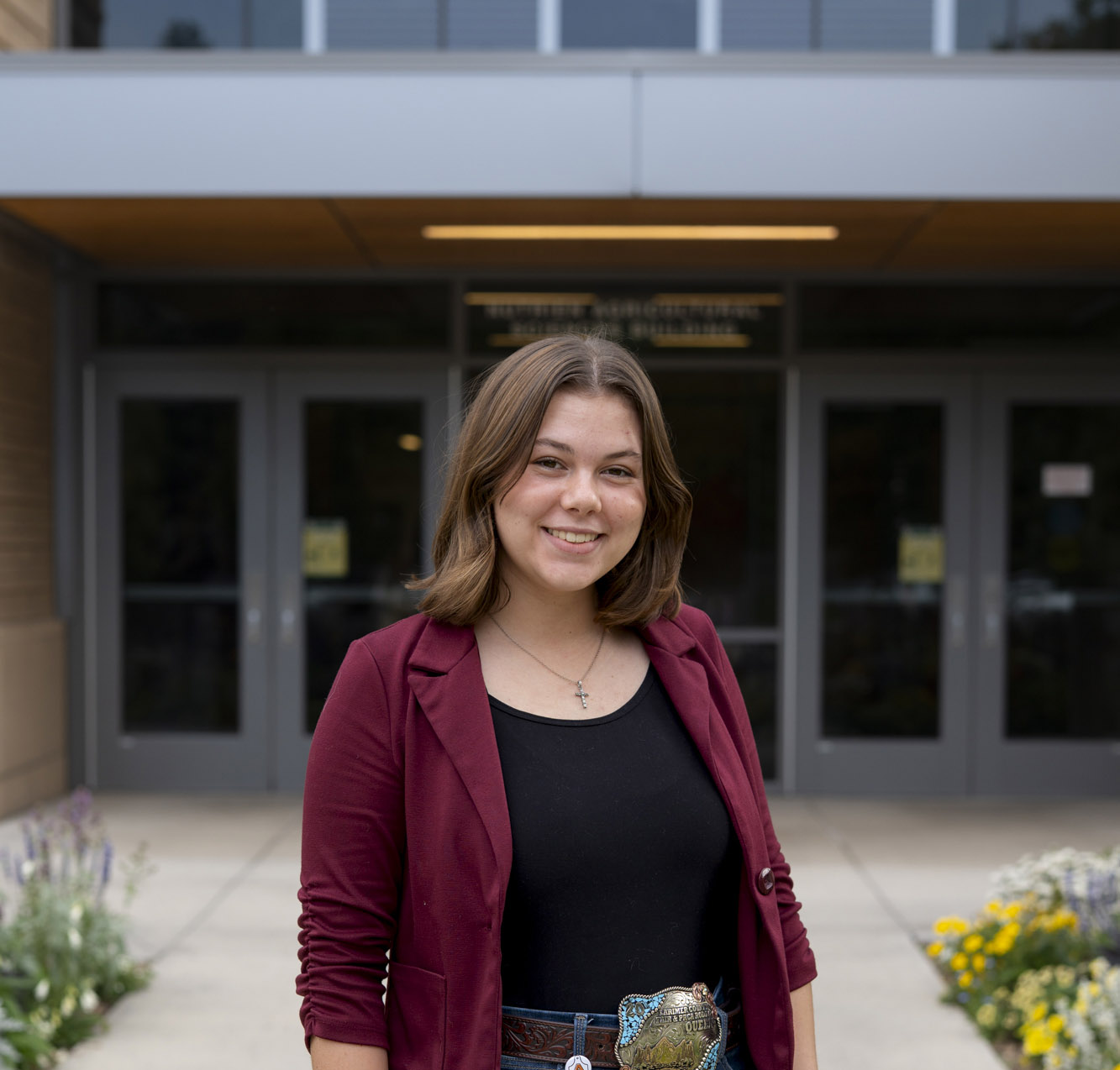 A headshot photo of Maggie Livingston standing in front of a building.
