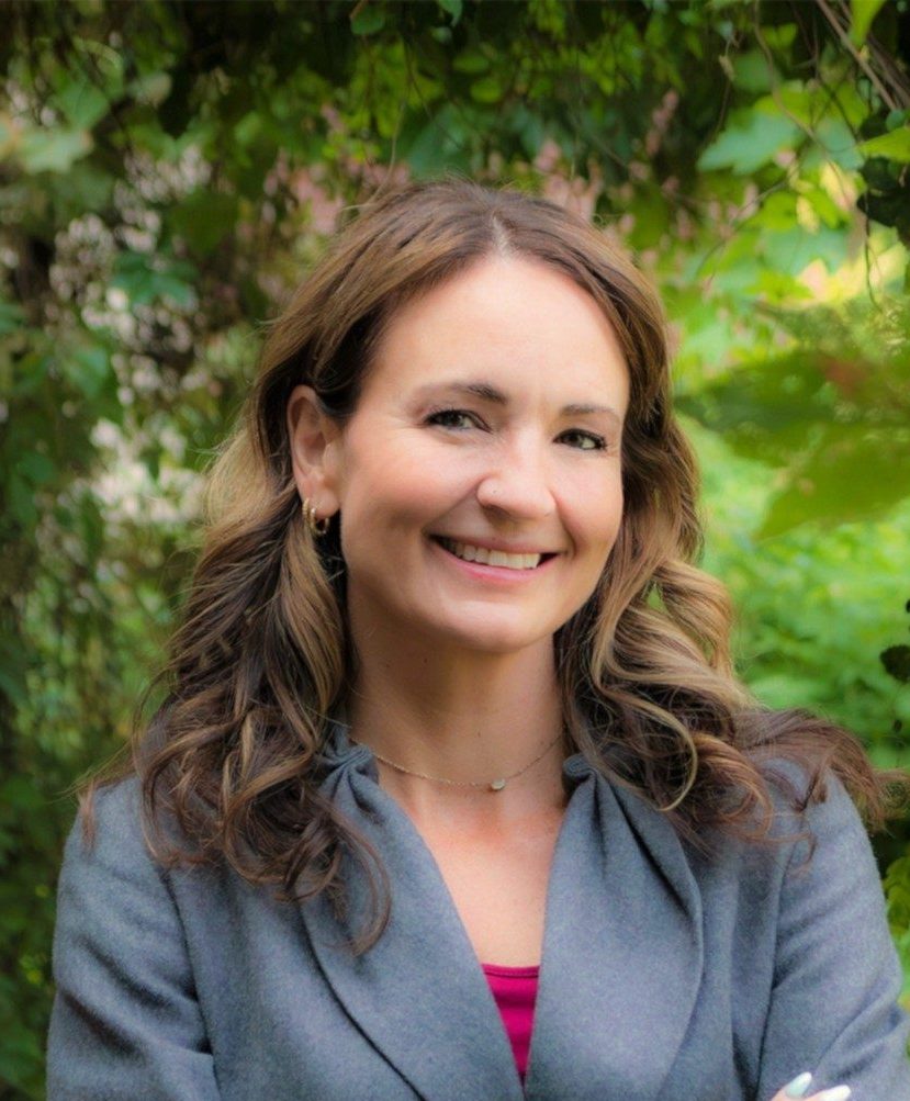 Dezarai Brubaker headshot photo in front of green foliage