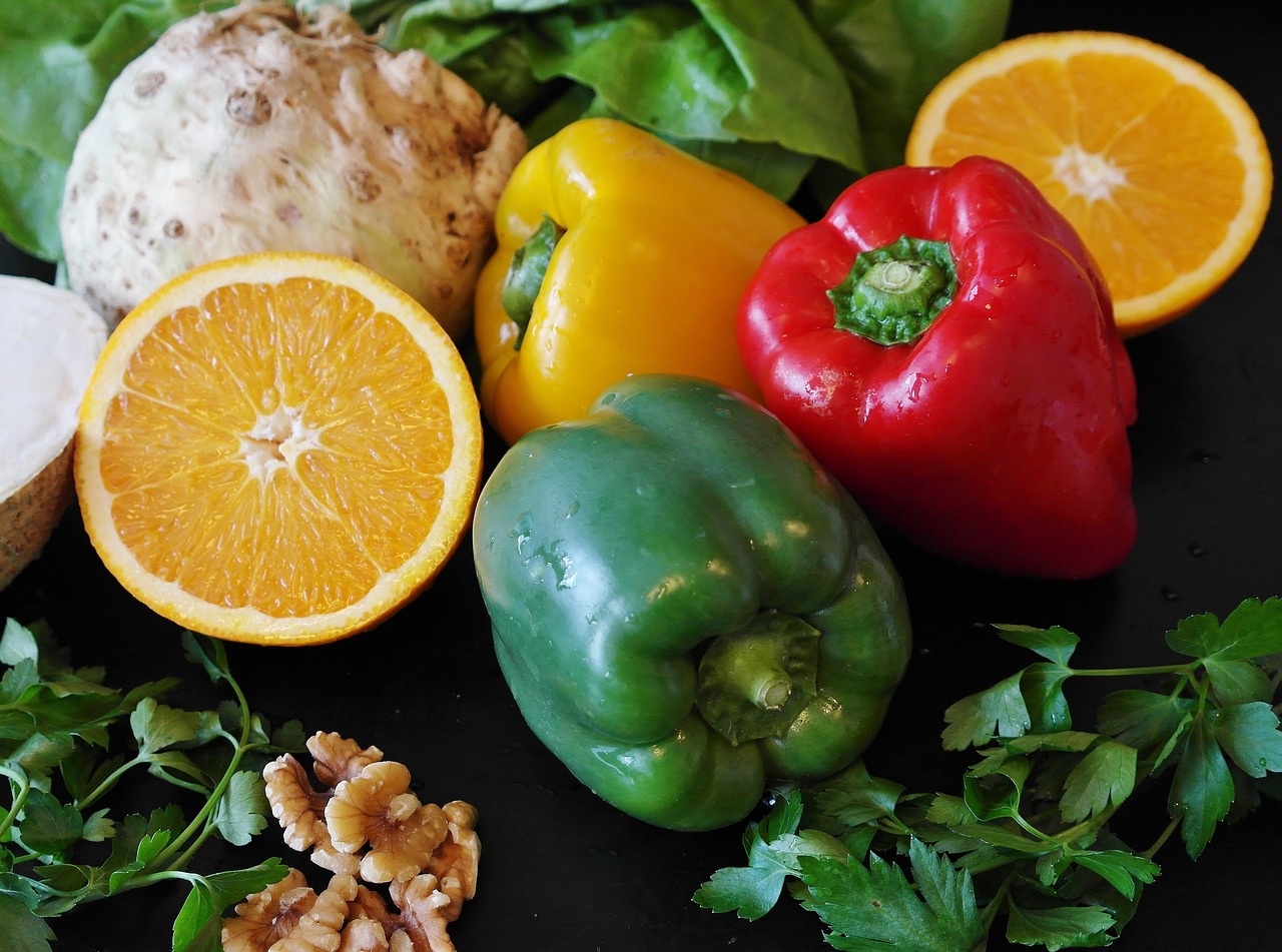 Peppers oranges herbs and nuts sitting on a table