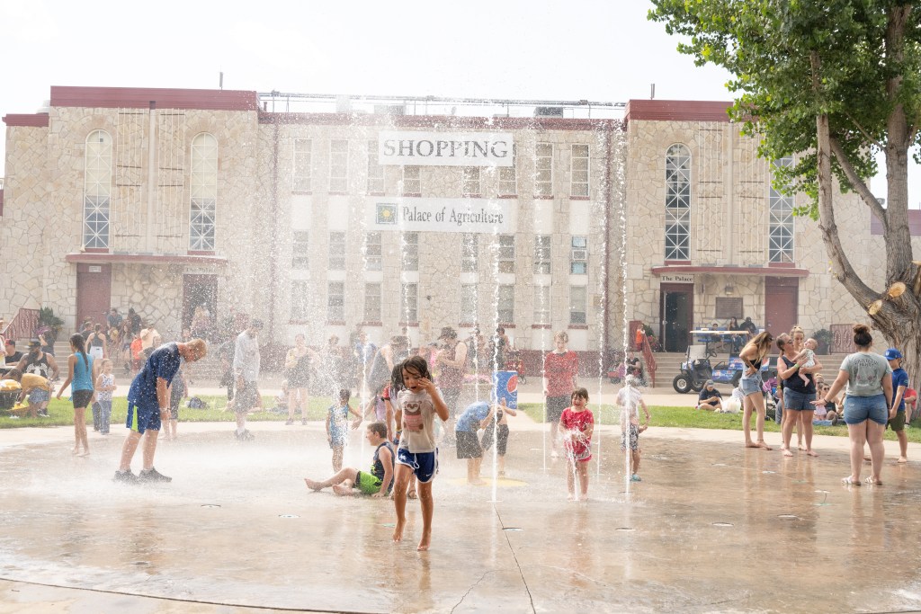 Kids playing at a splash pad at the Colorado State Fair.