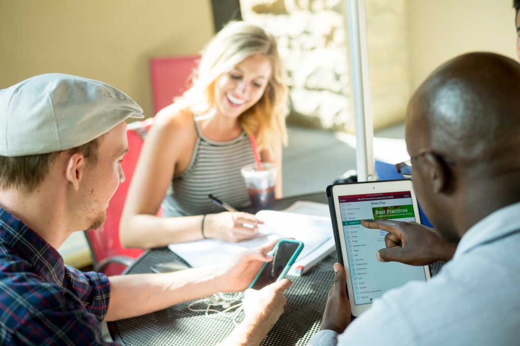 CSU students sitting outside at a cafe table, studying.