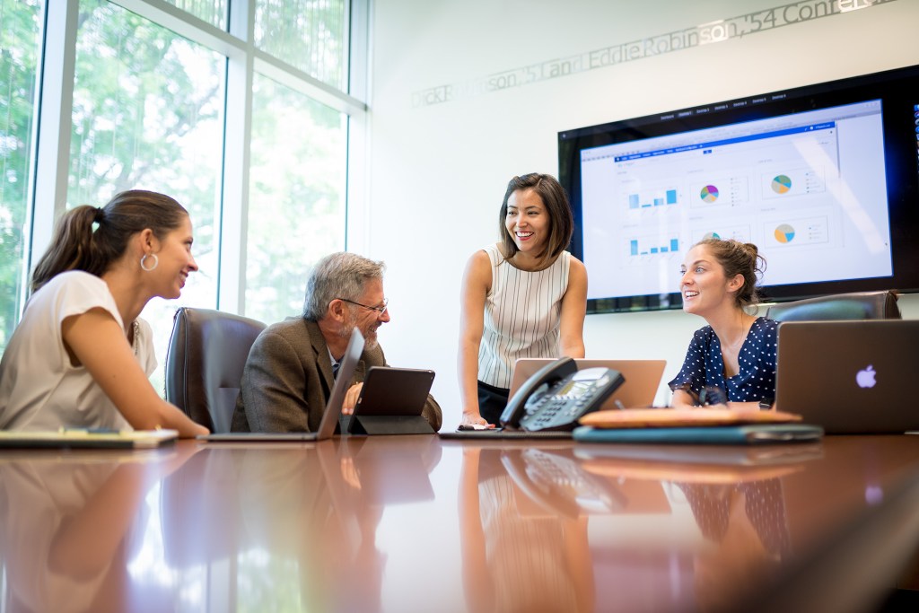 Woman presents to her team in a conference room.