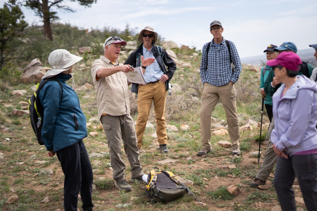 Group of seniors wearing hats outside hiking.