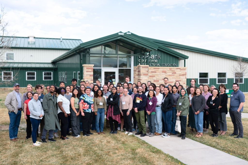 A group of students and faculty standing in front of the Gary R. and Georgia A. Hach Center for Agricultural Education at Colorado State University.