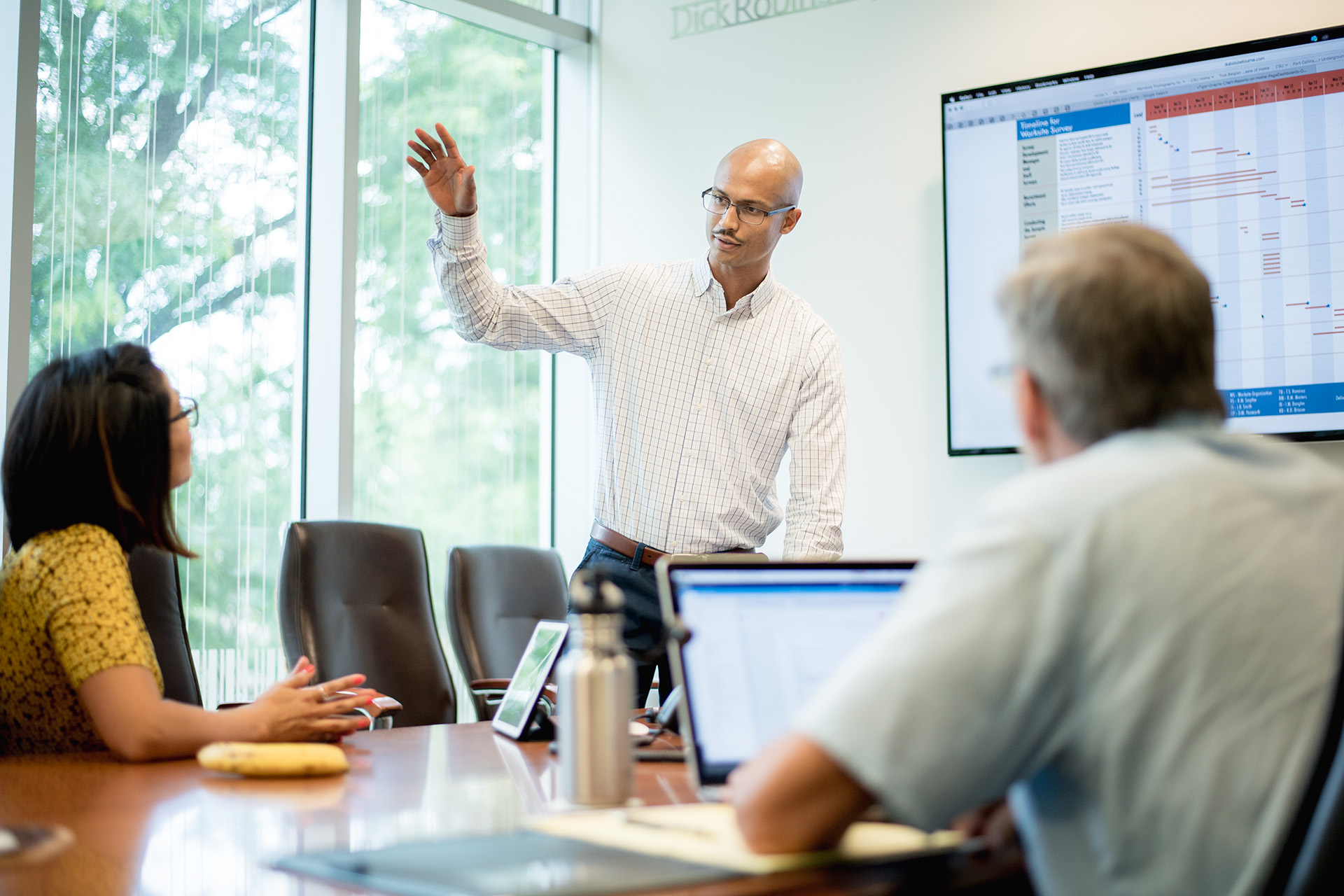 Man presents to his team in a conference room.