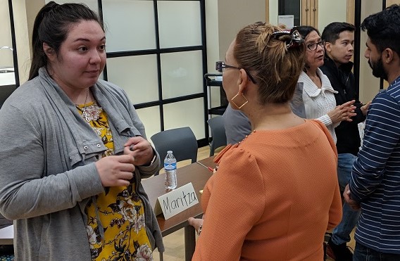 A group of people stand around a table at a community event.