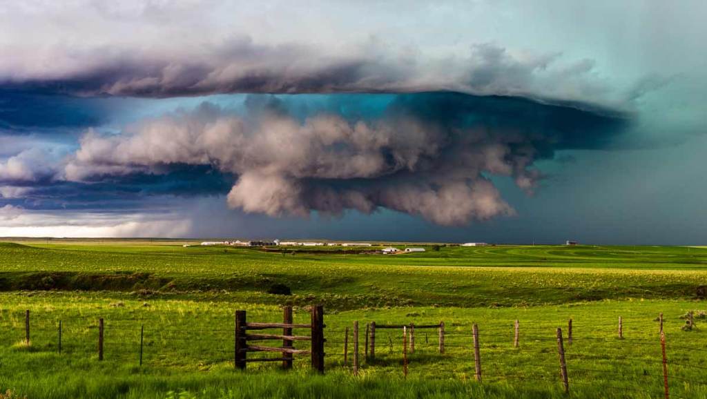 A tornado forming over a farmland.